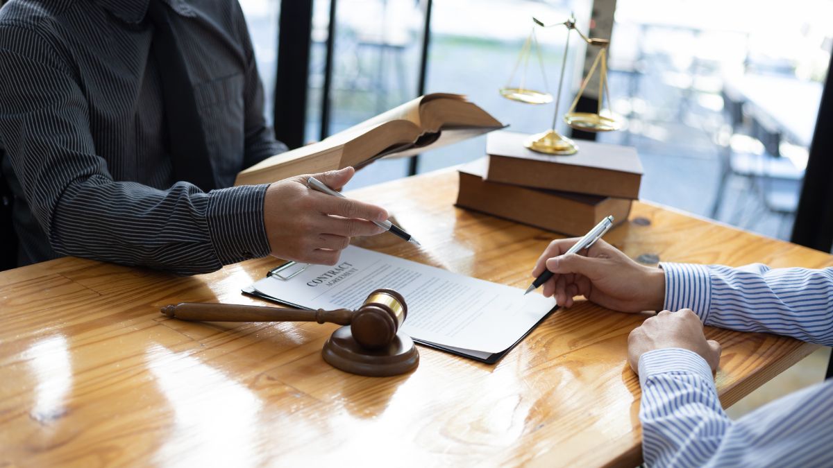 A lawyer advises a client on legacy protection strategies at a desk, featuring a gavel representing legal proceedings.